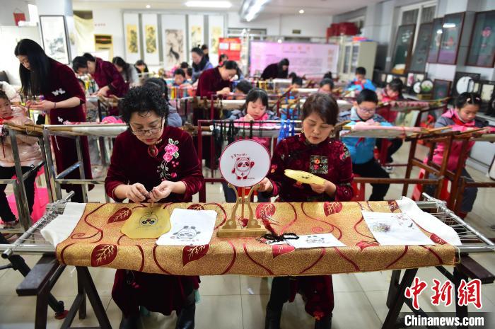 江西省級(jí)非遺豫章繡傳承人手把手指導(dǎo)小學(xué)生繡制2022年北京冬奧會(huì)吉祥物“冰墩墩”形象?！∮髟屏?攝