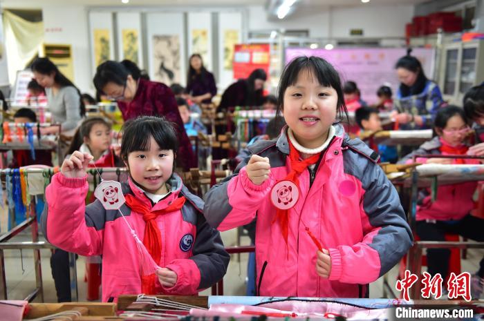 圖為小學(xué)生展示繡制好的2022年北京冬奧會(huì)吉祥物“冰墩墩”形象?！∮髟屏?攝