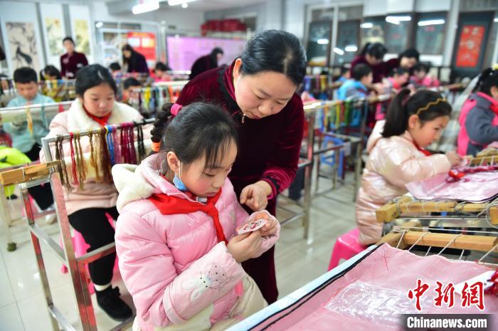 江西省級(jí)非遺豫章繡傳承人手把手指導(dǎo)小學(xué)生繡制2022年北京冬奧會(huì)吉祥物“冰墩墩”形象?！∮髟屏?攝