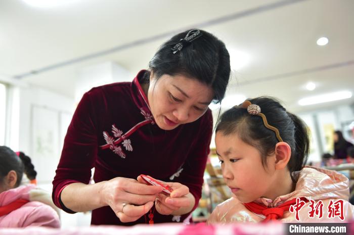 江西省級(jí)非遺豫章繡傳承人手把手指導(dǎo)小學(xué)生繡制2022年北京冬奧會(huì)吉祥物“冰墩墩”形象?！∮髟屏?攝