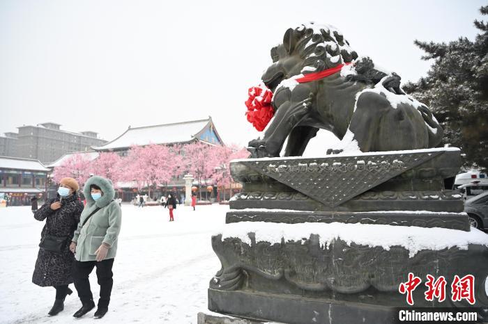 2月13日，民眾在呼和浩特市大召廣場雪中漫步?！⑽娜A 攝