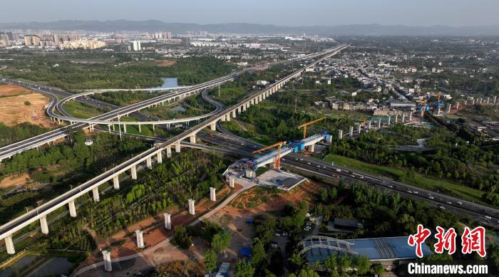 航拍正在建設的跨越成都繞城高速公路連續(xù)梁施工現(xiàn)場，旁邊依次為已運營的成渝高速鐵路和機場高速公路。　劉忠俊 攝
