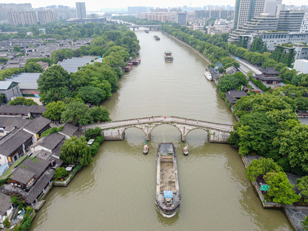 5月27日，一艘貨船駛過(guò)京杭大運(yùn)河南端標(biāo)志建筑杭州拱宸橋。(無(wú)人機(jī)照片)新華社記者江漢 攝