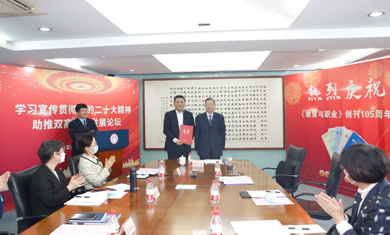 郝明金為《教育與職業(yè)》雜志編委代表陳曉明頒發(fā)聘書(shū)。中華職教社供圖