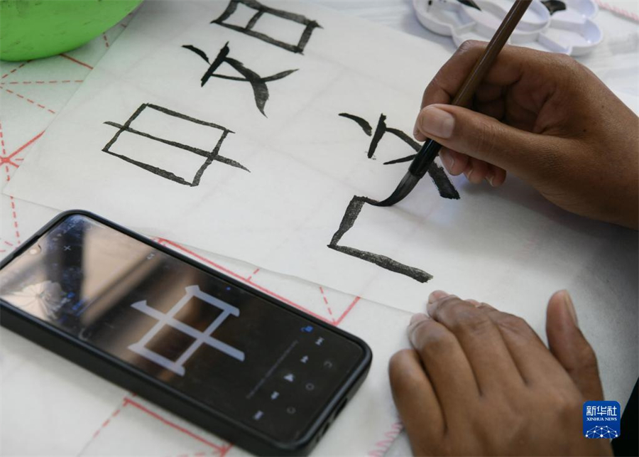 4月18日，肯尼亞學生在內(nèi)羅畢大學孔子學院舉辦的活動上寫毛筆字?？夏醽唭?nèi)羅畢大學孔子學院18日舉辦“中文，增進文明對話”主題活動，慶祝即將到來的第14個聯(lián)合國中文日。肯尼亞學生參與互動，進行書法、剪紙、唱中文歌等活動。新華社記者 韓旭 攝