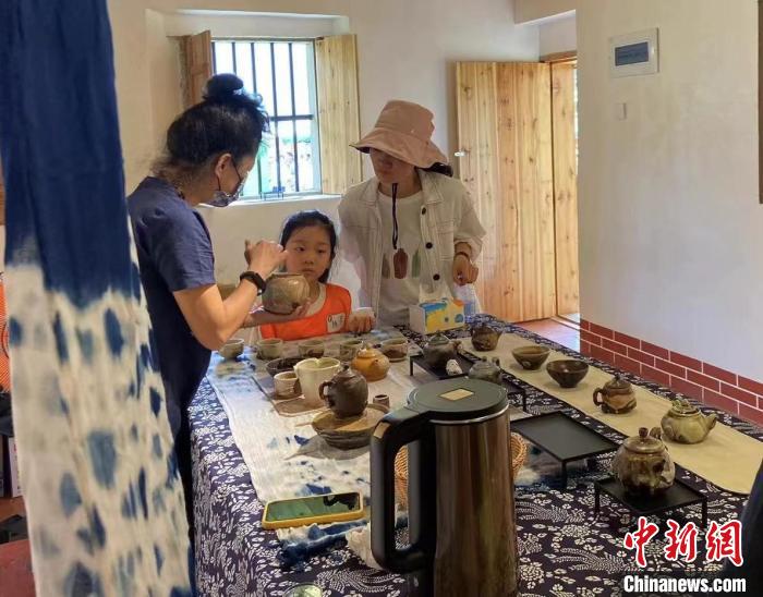 圖為：游客正在咨詢臺(tái)灣柴燒作品。　葉秋云 攝