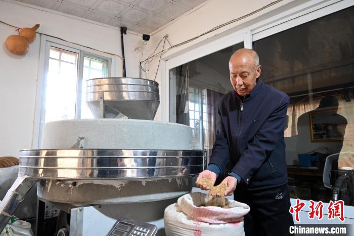 李家莊村民谷文朝重拾父輩的手藝，做起石磨面粉的營生?！〉杂鸺?攝