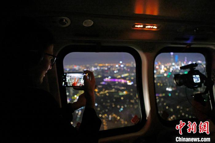 6月3日晚，游客乘坐上海新空直升機有限公司直升機開啟鳥瞰黃浦江空中圓夢之旅，并用手機拍攝城市夜景?！∫罅⑶?攝