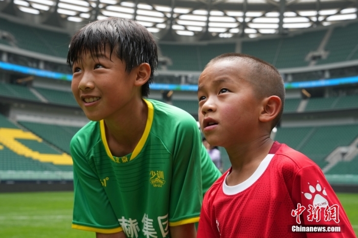 圖為北京國安小球員陳小北和7歲的俄金仁增在一起觀看場內(nèi)播放的紀(jì)錄片。<a target='_blank' href='/' _fcksavedurl='/'><p  align=
