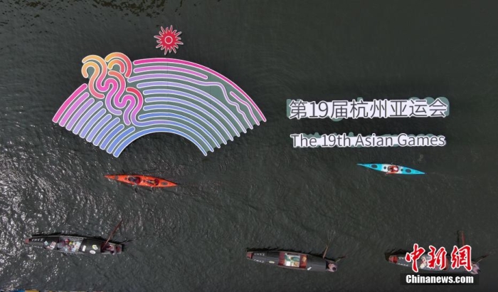 資料圖為烏篷船和皮劃艇從杭州亞運會標識前劃過。王剛 攝