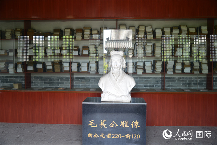 河間詩經齋毛萇雕像。雕像后書櫥中陳列的是歷代各版本《詩經》及譯本。 人民網(wǎng) 趙昭攝