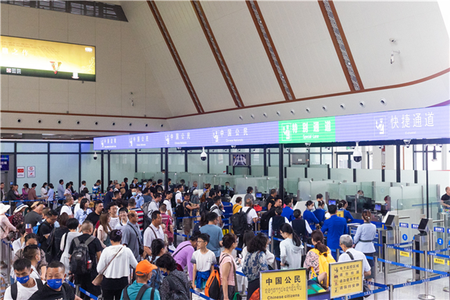 7月22日，乘坐中老鐵路國(guó)際旅客列車(chē)的旅客在磨憨邊檢大廳排隊(duì)候檢。衛(wèi)海林 攝