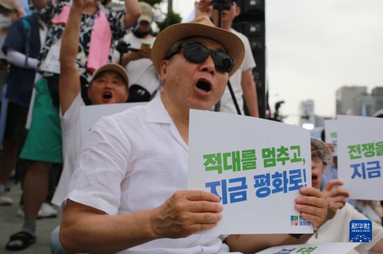 7月22日，在韓國(guó)首爾，人們手舉標(biāo)語(yǔ)參與反戰(zhàn)游行。新華社發(fā)（楊暢 攝）
