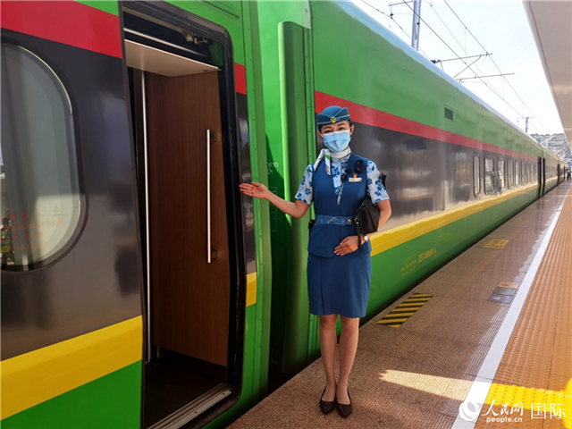 趙瑩靜站在“復(fù)興號”國際旅客列車車廂門口歡迎旅客上車。人民網(wǎng) 杜明明攝