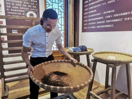 2023“一帶一路”媒體合作論壇聯(lián)合采訪團(tuán)團(tuán)員在非遺文化展示館體驗(yàn)中藥炮制技藝。（本報(bào)記者 黃超攝）