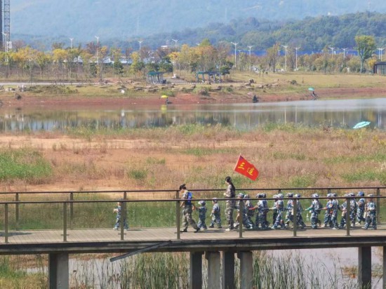 　　10月24日，秋游的幼兒園小朋友在老師帶領(lǐng)下走在清水塘公園里的木橋上。本報記者 常雯宜攝