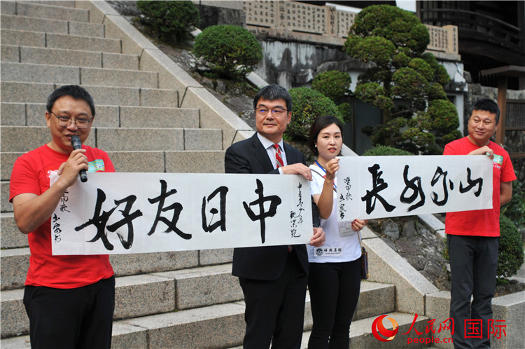 東京中國文化中心主任羅玉泉展示其為本次活動(dòng)書寫的題詞“中日友好，山高水長”。人民網(wǎng) 蔣曉辰攝