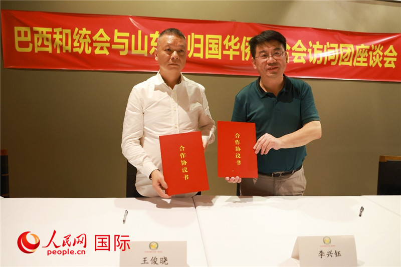 中國僑聯(lián)副主席、山東省僑聯(lián)主席李興鈺（右）與巴西和統(tǒng)會(huì)會(huì)長王俊曉簽署合作協(xié)議書。人民網(wǎng)記者 陳海琪攝