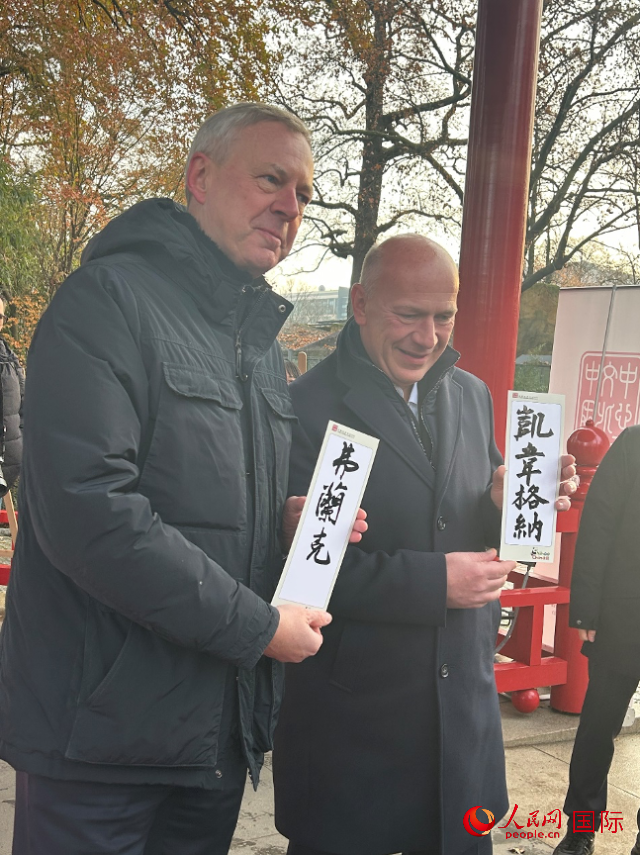 柏林市長韋格納（右）、動(dòng)物園監(jiān)事會(huì)主席布魯克曼（左）手持中國文化中心工作人員現(xiàn)場手書的中文名字。人民網(wǎng)記者 徐馨攝