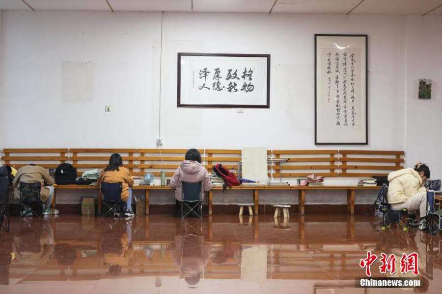 資料圖：幾位考研學(xué)生在南昌大學(xué)教學(xué)樓的公共空間復(fù)習(xí)備考。劉力鑫 攝