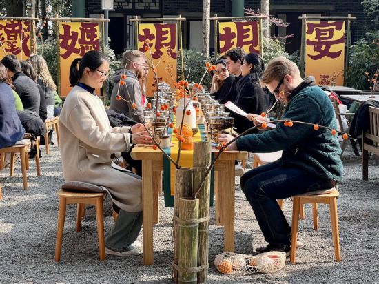 哥倫比亞大學青年學生代表團與蒲江縣鐵牛村村民一起交流、品嘗當地的小火鍋。