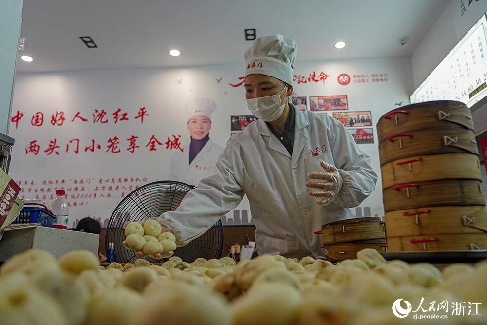 3月31日，在浙江省嵊州市甘霖鎮(zhèn)，嵊州小吃從業(yè)者沈紅平把蒸熟的小籠包晾涼，打包冷藏售賣。人民網(wǎng) 章勇濤攝