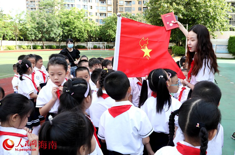 老師向少先隊員展示隊旗。人民網(wǎng) 符武平攝
