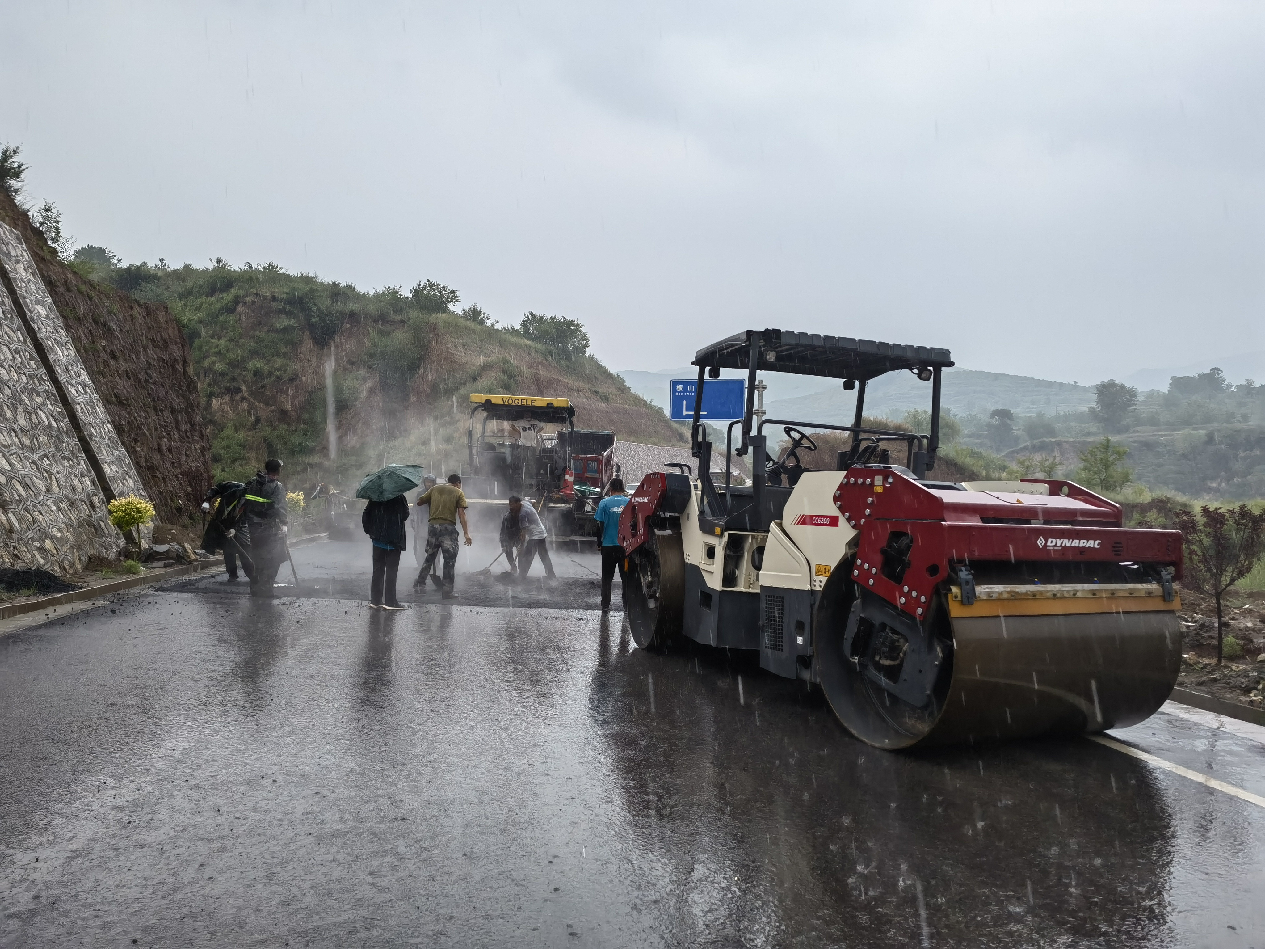 路橋工人在大雨中搶修道路。李華英 攝