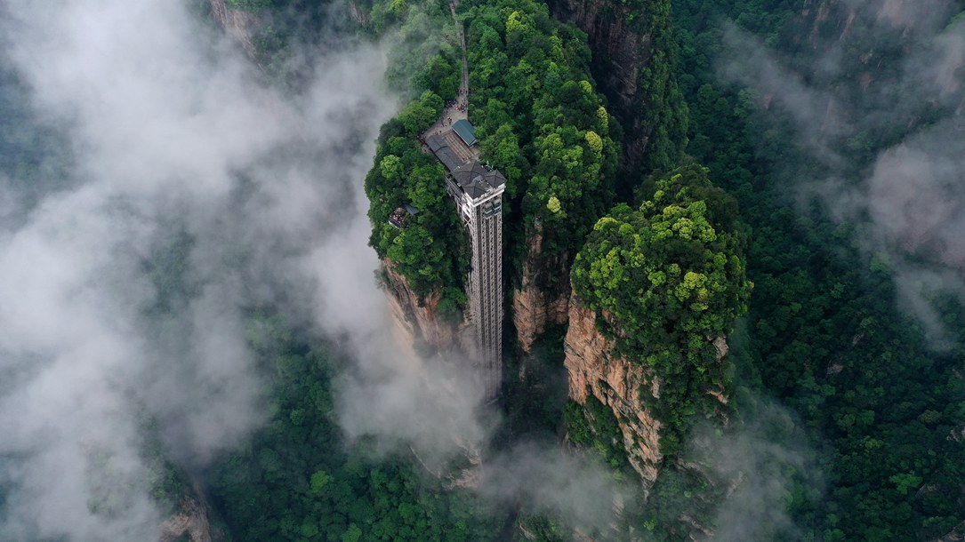 位于張家界武陵源景區(qū)的百龍?zhí)焯蓁偳对谠旗F繚繞的峰林間，雄偉壯觀。吳勇兵攝