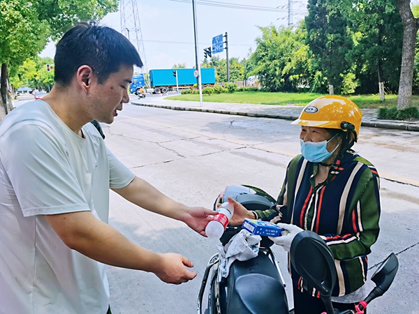 何超為過路的老人送上礦泉水和冷飲。人民網(wǎng)記者 王繼亮攝