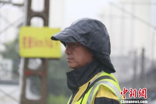 蘭州西工務(wù)段蘭州線(xiàn)路車(chē)間防護(hù)員雨中巡查?！⊥豕廨x 攝