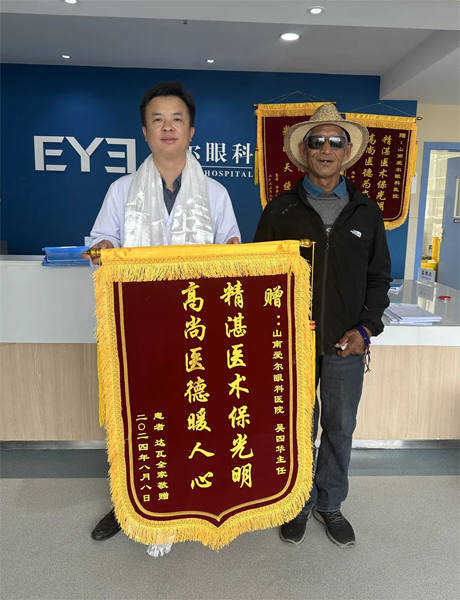 達(dá)瓦老人向吳四華（左）贈送錦旗。受訪者供圖