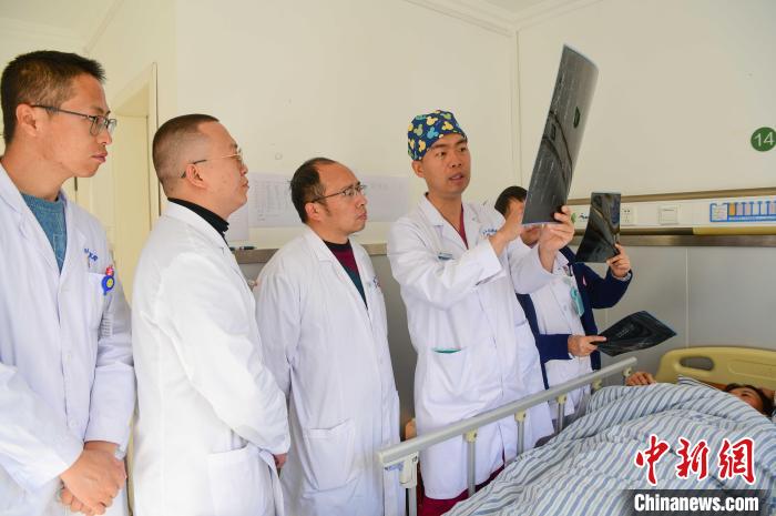 圖為醫(yī)療援藏專家何蔚(站右二)與馮敬云(左二)、廖濤(左三)等人討論患者病情。(資料圖) 貢嘎來松 攝