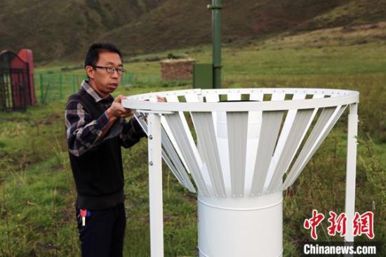 圖為班瑪縣氣象局工作人員在維護(hù)藏雪茶基地氣候站。青海省氣象局供圖