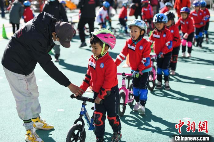 圖為拉薩市實驗幼兒園孩子們在教練的指導(dǎo)下練習滑步車?！『闻罾?攝