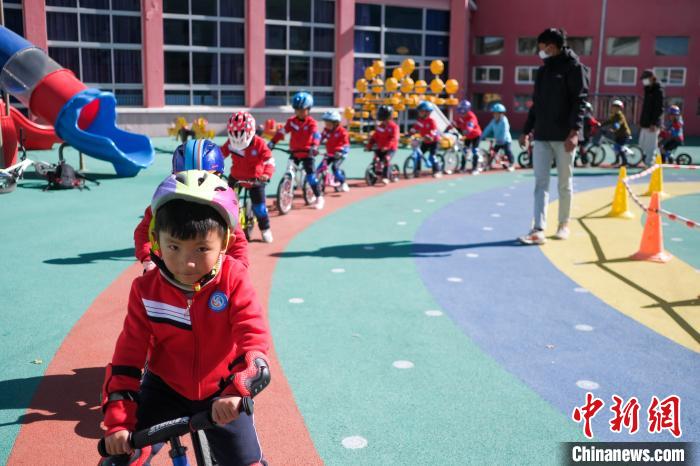 圖為拉薩市實驗幼兒園孩子們在教練的指導(dǎo)下練習滑步車?！『闻罾?攝