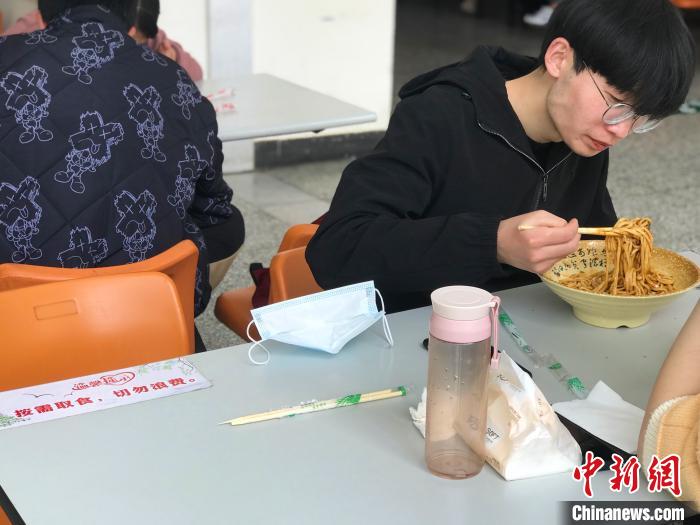 3月17日，西藏大學(xué)學(xué)生正在學(xué)校食堂用餐，餐桌上寫著“按需取餐，切勿浪費”。　冉文娟 攝