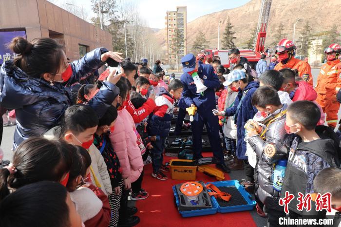 圖為小朋友們聽消防員講解消防器材。　楊龍建 攝