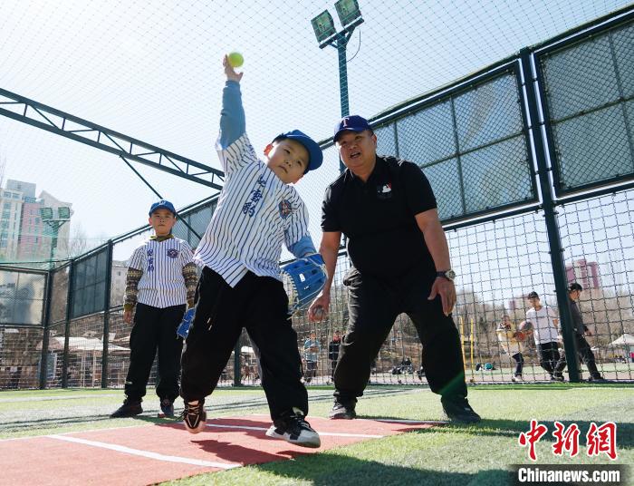 圖為來自臺(tái)灣的棒球教練劉興鴻(右)指導(dǎo)小棒球手?jǐn)S球技術(shù)?！●R銘言 攝
