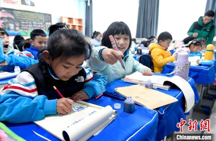 3月14日，西藏拉薩市第一小學一年級六班學生白瑪朗珍(圖左)在藏語文課上書寫藏文?！±盍?攝