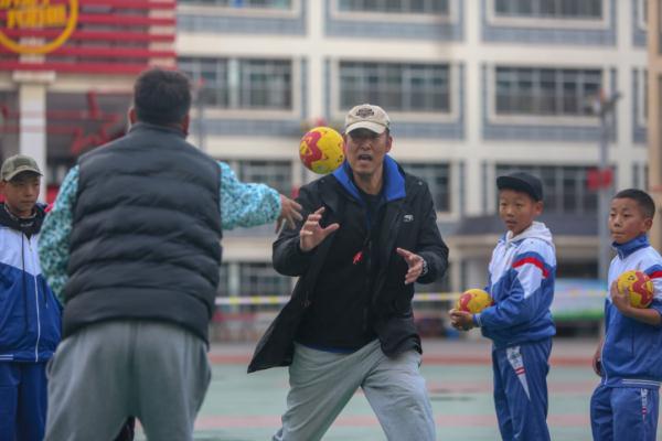在高原上教孩子們打手球，“慢慢兒來，甭著急！”