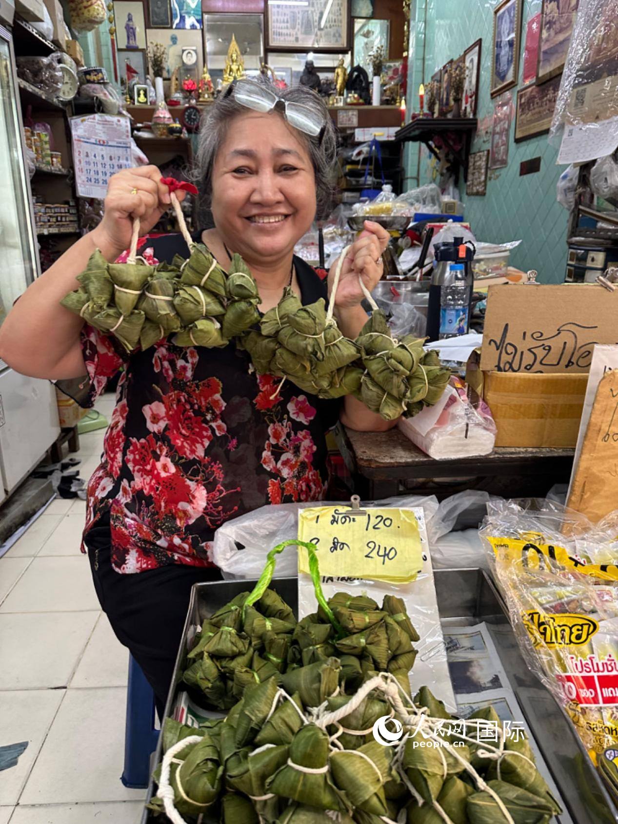 商家向顧客介紹“吉掌”（粽子的一種，一串一串，個(gè)頭較?。?。人民網(wǎng)記者 簡(jiǎn)承淵攝