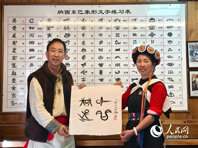 人民網(wǎng)“行進(jìn)中國”云南調(diào)研采訪團(tuán)走進(jìn)麗江，和閏元現(xiàn)場用東巴文寫下“行進(jìn)中國”。人民網(wǎng)記者 符皓攝