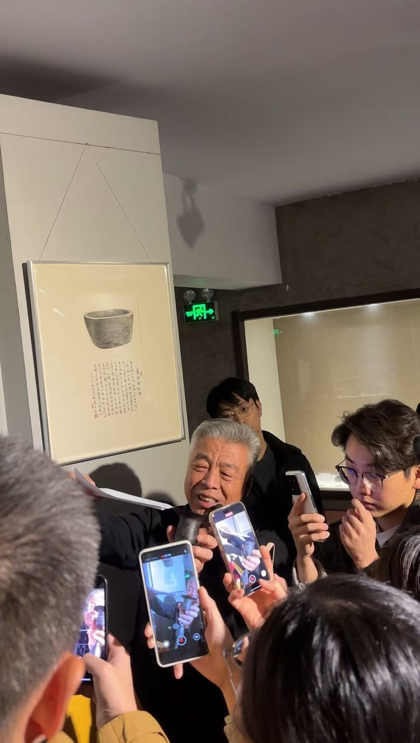 黑陶邢文化博物館館長邢葆東展示兩張相疊的A4紙，向記者解釋此為杯口的厚度。