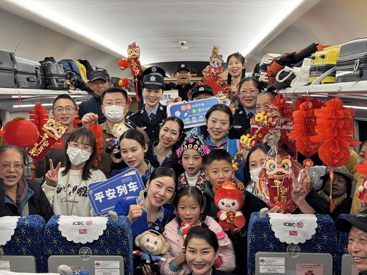 春節(jié)期間，在中老鐵路磨萬（磨丁—萬象）段，鐵路客運員工與乘客合影留念。李加勇攝