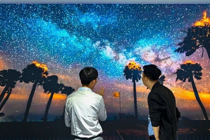 長春光博會希達電子展區(qū)，一位工作人員正在給一位觀眾講解。（長春新區(qū)供圖）