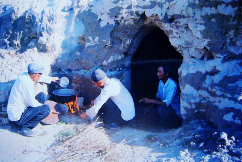 1983年，“六老漢”一代治沙人在“地窩子”生活做飯。新華社發(fā)（八步沙林場供圖）