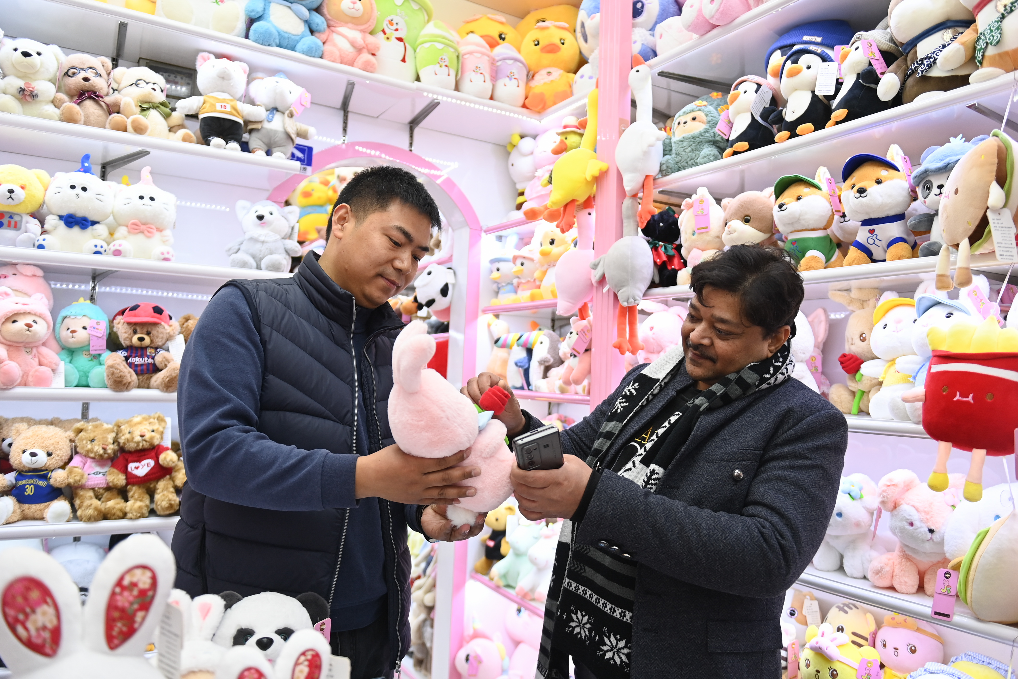 2023年2月2日，來自印度的客商（右）在義烏國際商貿(mào)城的一家玩具店鋪內(nèi)選購。