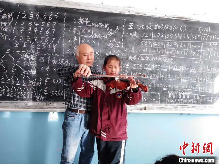 圖為趙興洲教學(xué)生拉小提琴。受訪者提供