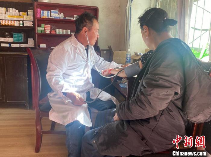 索木滾(左)為村民看病。　壤塘縣委宣傳部供圖